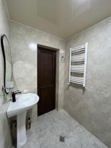 a bathroom with a sink and a mirror and a door at Garden house in Akhaltsikhe