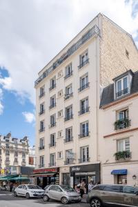 a white building with cars parked in front of it at Havre de Raffinement à Levallois-Perret in Levallois-Perret