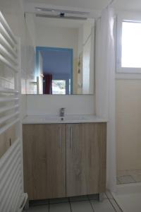 a bathroom with a sink and a mirror at Maison 4 personnes avec piscine in Dolus d'Oléron