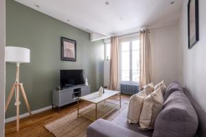 a living room with a couch and a table at Havre de Raffinement à Levallois-Perret in Levallois-Perret