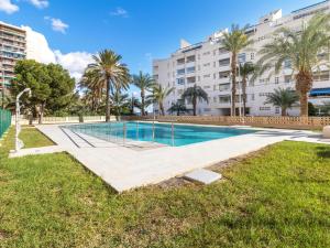 a swimming pool with palm trees and a building at Apartamento Sea View Aguadulce in Aguadulce