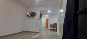 a hallway with a white wall with a tv on it at los QUISPER in San Bernardo