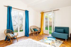 d'un salon avec des meubles bleus et des fenêtres. dans l'établissement 910 - Maison 4, plage à pied, à Pornic