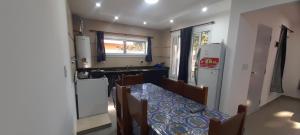 a kitchen with a dining table and a kitchen with a refrigerator at los QUISPER in San Bernardo