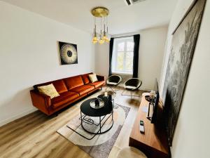 a living room with a couch and a table at Hypercentre, spacieux, lumineux, climatisé, le Quai de Loire in Blois