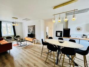 a kitchen and living room with a table and chairs at Hypercentre, spacieux, lumineux, climatisé, le Quai de Loire in Blois