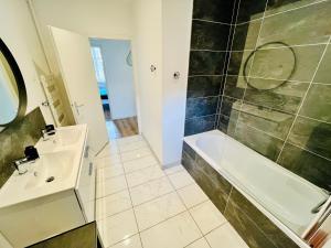 a bathroom with a sink and a tub and a shower at Hypercentre, spacieux, lumineux, climatisé, le Quai de Loire in Blois +28 photos