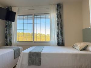 Un dormitorio con dos camas y una gran ventana. en Villa Leonardo, en Castelldefels 94 fotos más