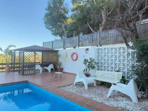 Un patio con un banco y una piscina. en Villa Leonardo, en Castelldefels