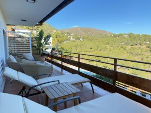 Un balcón con sillas, mesas y vistas. en Villa Leonardo, en Castelldefels