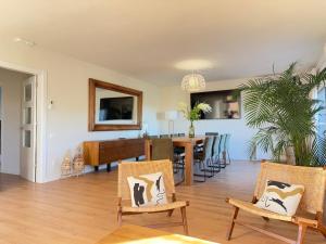 Un comedor y una sala de estar con mesa y sillas. en Villa Leonardo, en Castelldefels