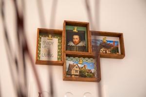 eine Reihe von Bilderrahmen, die an einer Wand hängen in der Unterkunft The Shakespeare Townhouse - Stratford upon Avon in Stratford-upon-Avon