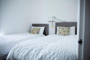 ein Schlafzimmer mit zwei Betten mit weißen Laken und Kissen in der Unterkunft The Shakespeare Townhouse - Stratford upon Avon in Stratford-upon-Avon + 15 Fotos