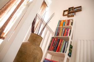 eine Vase auf einem Tisch neben einem Bücherregal in der Unterkunft The Shakespeare Townhouse - Stratford upon Avon in Stratford-upon-Avon