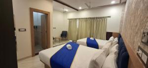 a hotel room with two beds and a doorway at BlueNeck Ayodhya-Near ShriRam Mandir in Ayodhya