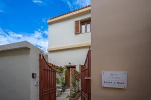 un edificio blanco con una puerta y una señal en él en Rocca a Mare Maisonette II, en Heraclión