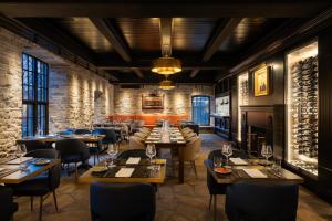 a restaurant with tables and chairs and a fireplace at Old Mill Toronto Hotel in Toronto