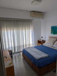 een slaapkamer met een bed en een raam met gordijnen bij Ático Palermo in Buenos Aires