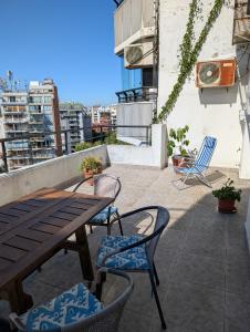 een patio met een houten tafel en stoelen op een balkon bij Ático Palermo in Buenos Aires +55 foto's