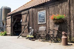 a wooden building with chairs and a sign on it at Boerenerf Lodge - Erf 1 in Kampen