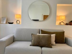 a living room with a couch and a mirror at Studio du port - Porte marine in Antibes