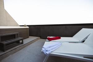 a bathroom with a white bench and a sink at SO City Hotel Adults Only in St. Julianʼs