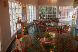 a dining room with tables and chairs and windows at Humbi Farm in Xai-Xai +33 photos