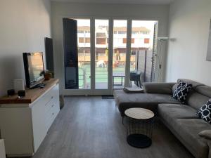 a living room with a couch and a tv at Punta Faro in Lignano Sabbiadoro