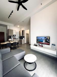 a living room with a couch and a tv on a wall at Sunsuria Forum - Masuyo Homes in Shah Alam