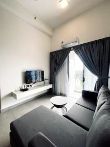 a living room with a couch and a tv at Sunsuria Forum - Masuyo Homes in Shah Alam