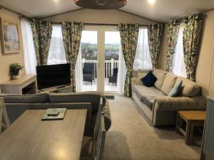 una sala de estar con un sofá y una mesa en Modern home with amazing views, en Bembridge