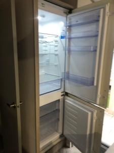 Un refrigerador vacío con la puerta abierta en una cocina. en Modern home with amazing views, en Bembridge