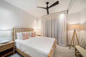 Un dormitorio con una cama y un ventilador de techo. en Allure 102 apts, en Bridgetown