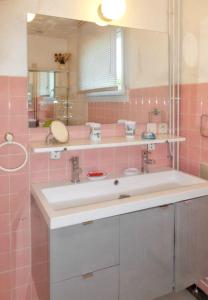 プルガヌーにあるMaison charmante à Plougasnou + Vue merのピンクのタイル張りのバスルーム(シンク、鏡付)
