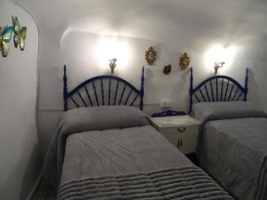 a bedroom with two beds and a table and lights at Cueva mágica de Raspay in Raspay