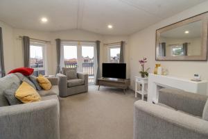 a living room with two couches and a television at Longdon Lodge in Evesham