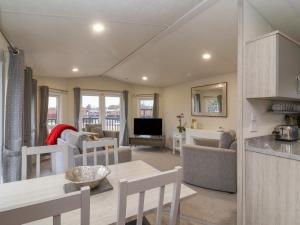 a kitchen and living room with a table and chairs at Longdon Lodge in Evesham