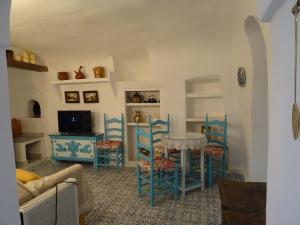 a living room with blue chairs and a table at Cueva mágica de Raspay in Raspay