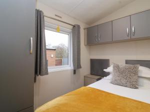 a small bedroom with a bed and a window at Longdon Lodge in Evesham