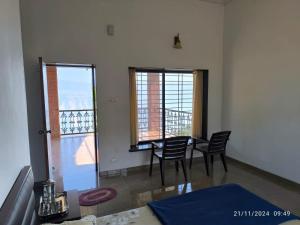 ein Esszimmer mit einem Tisch und Stühlen sowie einem Balkon in der Unterkunft Eagle Eye Resort in Mahabaleshwar + 44 Fotos