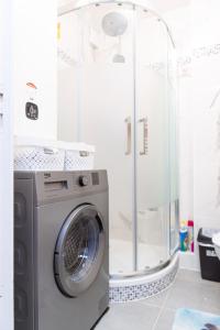 a washing machine in a bathroom with a shower at T2 a stone's throw from Gare Amiens in Amiens
