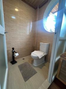 a bathroom with a toilet and a window at Bugnay Cabin of The Shire in Sagada +8 photos