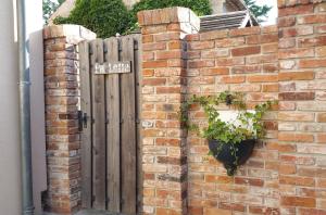 a brick wall with a gate and a potted plant at Ferienwohnungen _ Haus Lisa_ in Senftenberg +25 photos