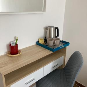 un bancone con due tazze e una macchina del caffè sopra di En-suite Triple Room-Giardino A Mare a Donnalucata