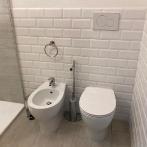 un bagno bianco con un water e un lavandino di En-suite Triple Room-Giardino A Mare a Donnalucata