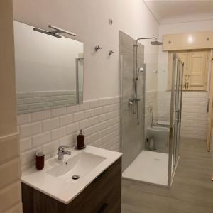 un bagno bianco con lavandino e doccia di En-suite Triple Room-Giardino A Mare a Donnalucata