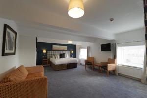a hotel room with a bed and a couch and chairs at THE LORD NELSON HOTEL in Pembrokeshire