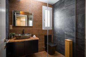 a bathroom with a sink and a mirror at Comme a la maison in Corfu Town