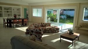 a living room with a couch and a table at Casas de férias in Guarujá