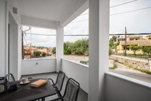 a balcony with a table and chairs and a view of a street at Comme a la maison in Corfu Town +5 photos